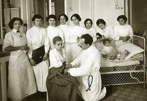 Группа студенток наблюдает, как врач осматривает ребёнка