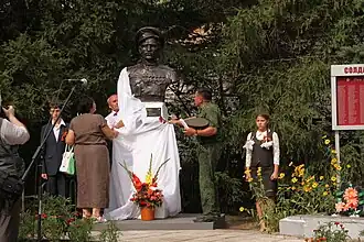 Открывают памятник глава администрации муниципального образования «Прибрежненское сельское поселение» Юрий Мощенко, руководитель межрегиональных Российских и международных программ РО ММФ ЮНЕСКО в Поволжье «100-летие Первой Мировой войны, памяти солдат и офицеров Русской императорской армии» Дмитрий Борисов и Виталий Ворохобин, родственник Владимира Ивановича Долматова.