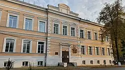 Бежевое 2-этажное здание с подвальными помещениями. У главного входа (тёмно-коричневая дверь) висит золотые герб университета и надпись: «Пермский государственный медицинский университет имени академика Е. А. Вагнера»