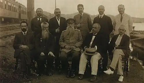 Правительство (деловой кабинет) генерала Л. Д. Хорвата. Владивосток. Сидят: Л. А. Устругов, М. О. Курский, Д. Л. Хорват, С. В. Востротин, В. Е. Флуг. Стоят: С. В. Таксин, В. Е. Алферьев, А. М. Окороков, В. А. Глухарёв, проф. Я. Я. Брандт. 1918 год (ГА РФ).