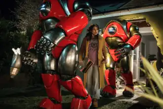 Роботы похищают Белинду Чандру, которая держит в руках звёздный сертификат