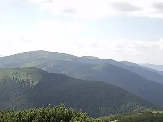 Русская на втором хребте крайняя правая вершина, высшая крайняя левая Братковская, за ней вдали — Гропа. Фото с вершины Чёрная Клева