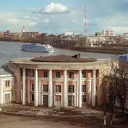 Площадь речного вокзала. От причала вниз по Волге отплывает круизный теплоход. Здание вокзала не используется по прямому назначению с 2002 года.