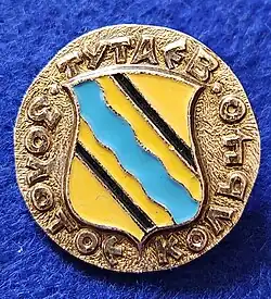 Значок из геральдической серии «Золотого Кольца России» 1970-х годов с историческим гербом уездного города  Рома́нов-Борисогле́бск Ярославской губернии.