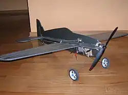 На верхней плоскости правого крыла видны две параллельные проволочки — «корды», тянущиеся до ручки управления в руках у спортсмена. На фюзеляже установлена качалка управления, проволочной тягой она соединена с рулём высоты.