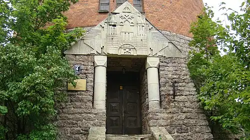 Деталь башни — каменный портал со стилизованным гербом Риги