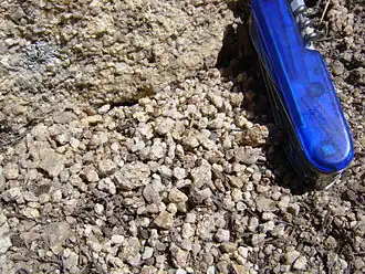 Гранитоид (вверху) рассыпается в дресву (внизу). Ширина ножа — около 2 см.